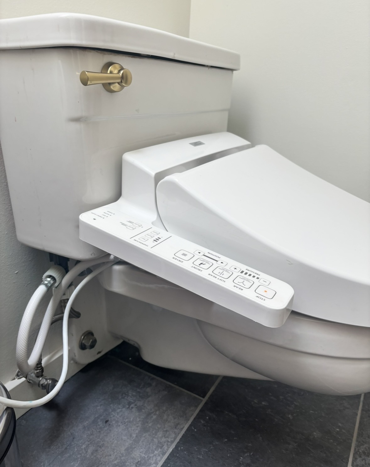 Wall-mounted toilet with bidet seat — cosmetic upgrade over original 1960s plumbing